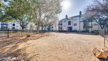 Dog park with gravel surface and mature trees